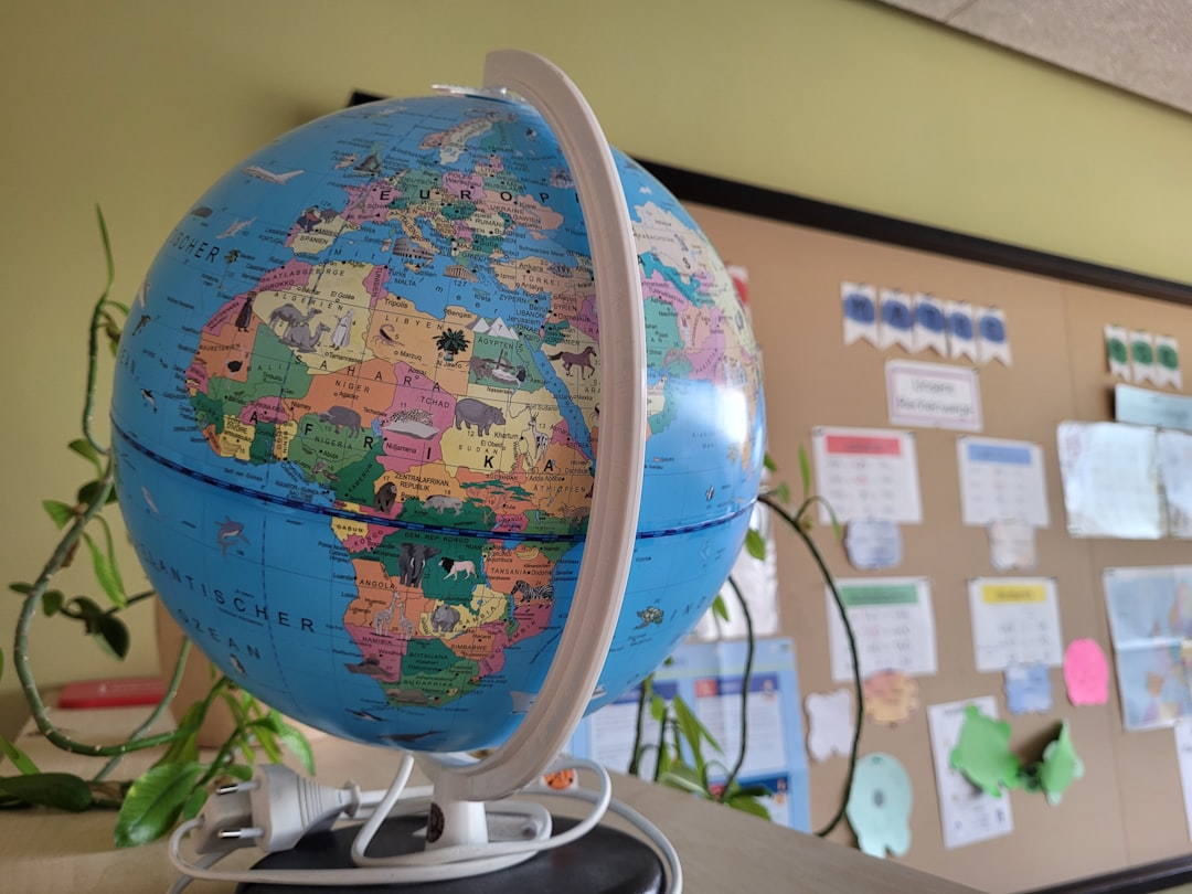 elementary school students studying a globe together in a classroom